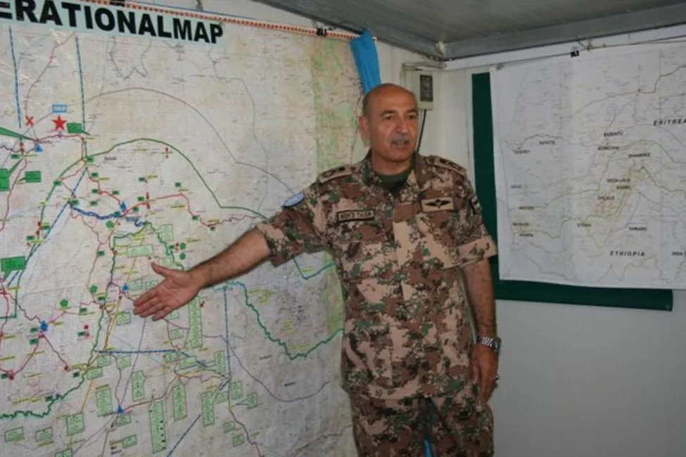 Force Commander Major General Mohammad Taisir Masadeh (Jordan) briefs peacekeepers at the Jordanian Headquarters in Barentu, Eritrea (UNMEE Photo: Ian Steele) A man in military uniform standing in front of a large map indicating a section of the map with an open hand.