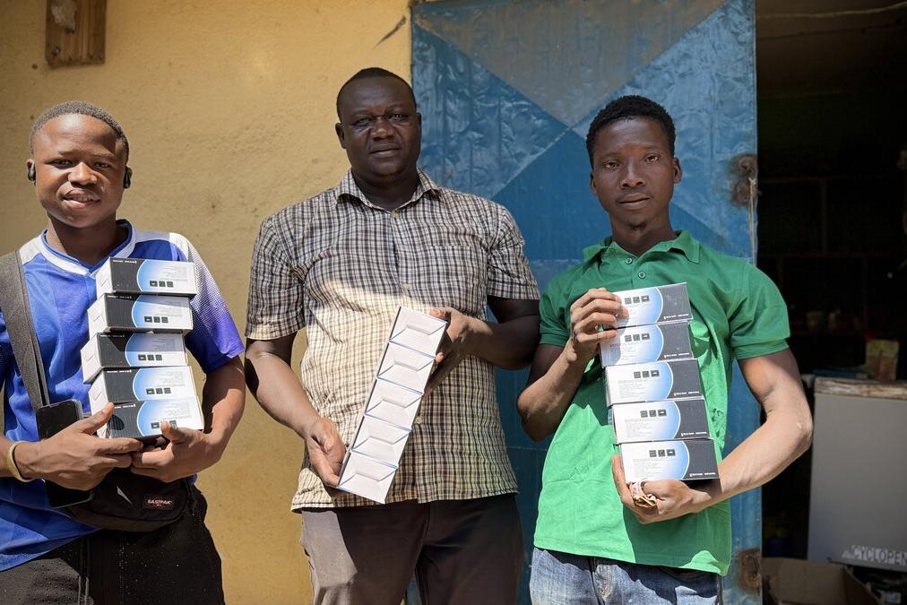 Trois personnes tiennent le matériel.